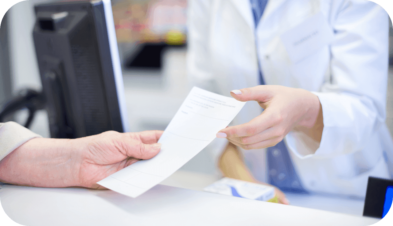 Patientin überreicht Apothekerin Ihr Rezept